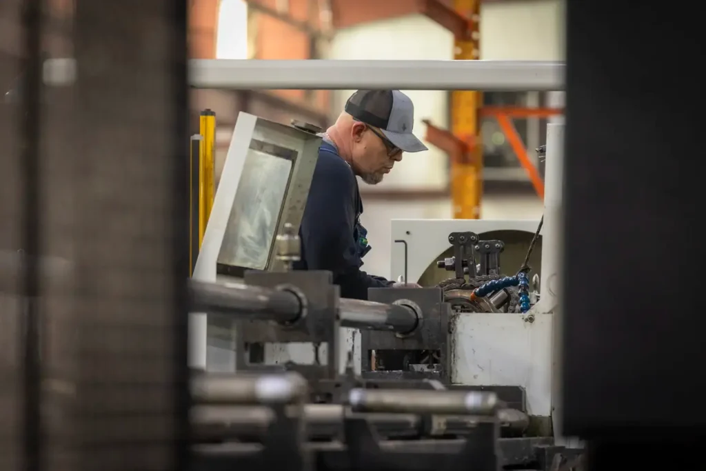 Man repairing cylinder with a machine